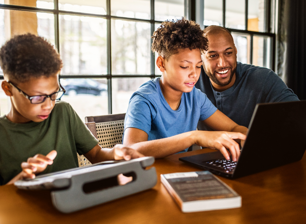 Father on devices with sons