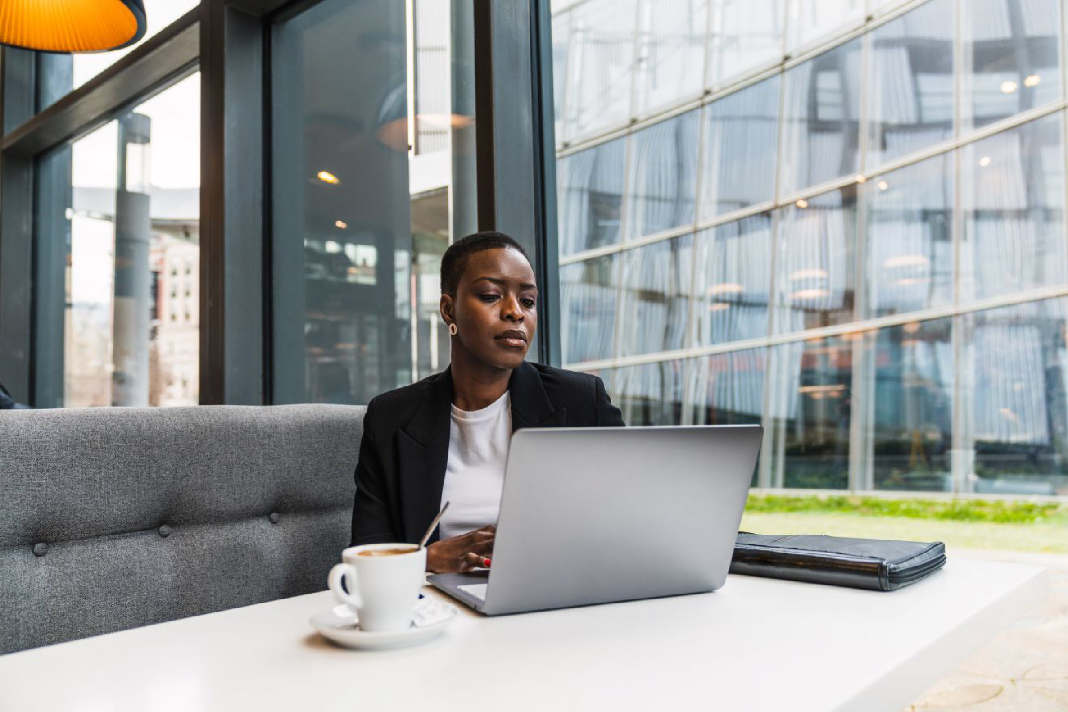 woman sitting at her laptop in front of a window in a business setting