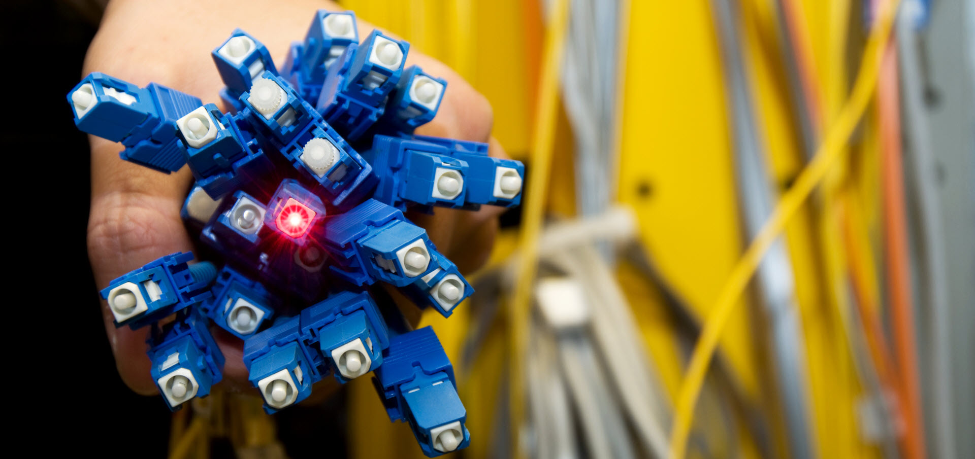 Person holding blue and yellow cables